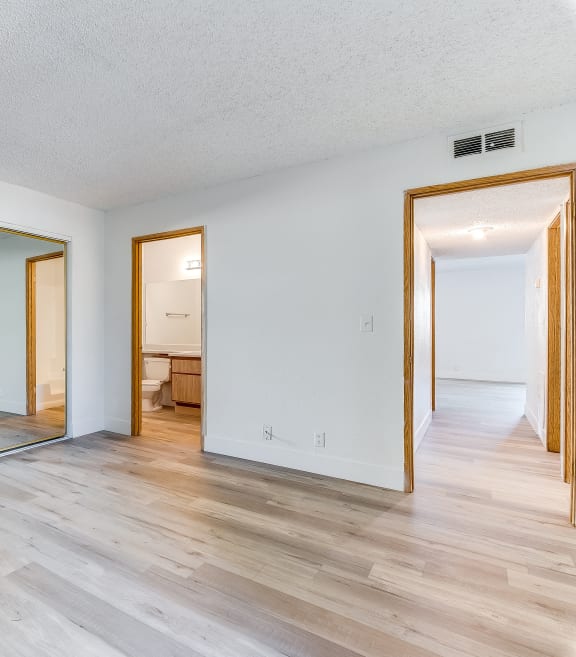 the living room and dining room of a house with mirrors on the wall and a