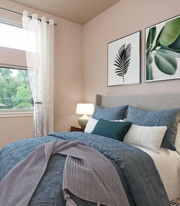 a bedroom with a bed with pillows and a comforter and a window