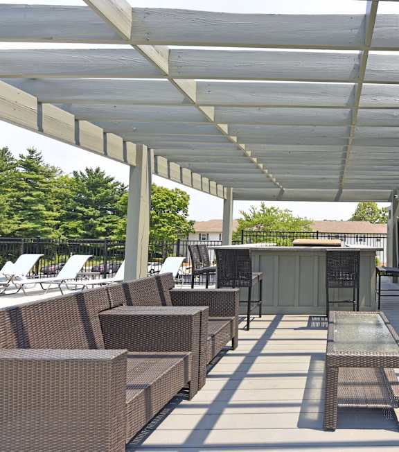 A patio with a table and chairs under a white roof.