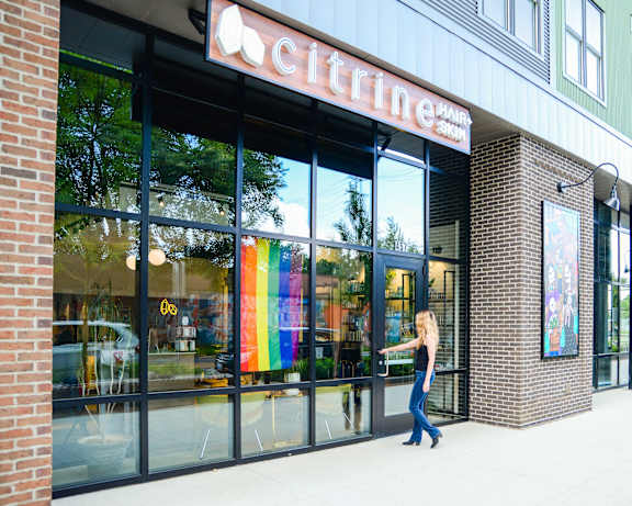 a woman walking down a sidewalk in front of a grocery store