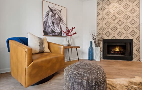 a living room with a leather chair and fireplace