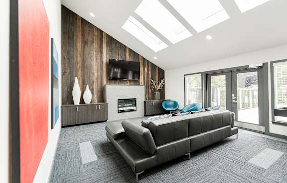 A modern living room with a grey sofa and a fireplace.