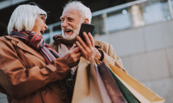 an older man and woman looking at a cell phone