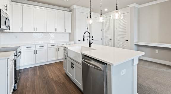 A modern kitchen with white cabinets and a large island.