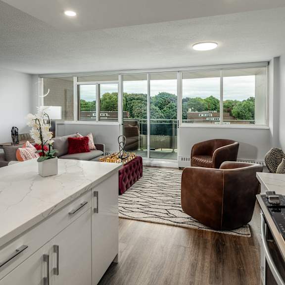 A modern kitchen with a brown chair and a marble countertop.