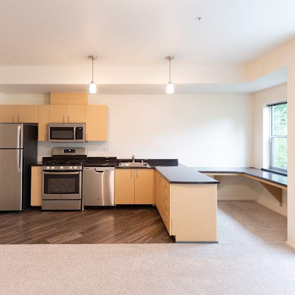 A modern kitchen with stainless steel appliances and wooden cabinets.