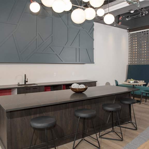 A modern kitchen with a bar area and a couch.