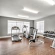 A gym with treadmills, exercise bikes, and weight machines.