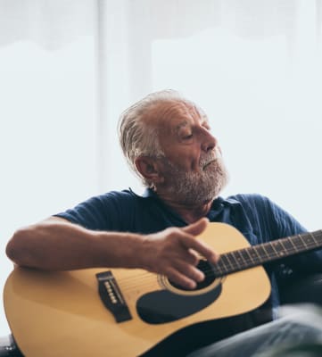 Man Playing Guitar at Hendrix Apartments- A 55+ Lifestyle Community