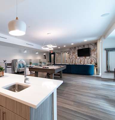 A modern kitchen with a white countertop and wooden cabinets.