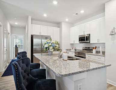 a white kitchen with a granite counter top and white cabinets