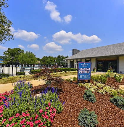 A leasing center with a garden in front.
