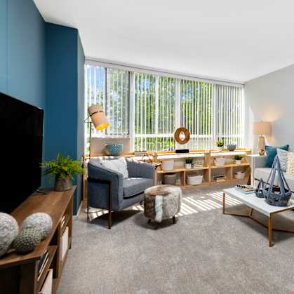 A living room with a grey sofa, a coffee table, and a painting on the wall.