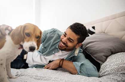 a man laying on a bed with a dog