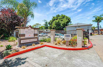 The image shows the entrance to the Willow Apartments with a sign and a red circular border.