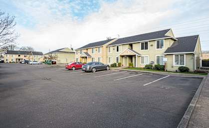 a parking lot filled with cars in front of houses