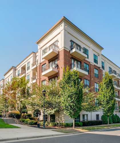 A large apartment building with a grassy area in front.