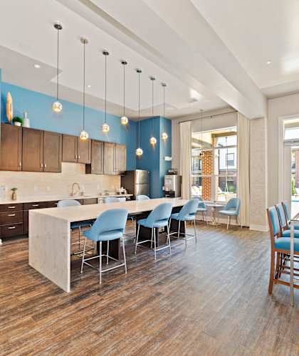 A kitchen with a dining table and chairs in the middle of the room.