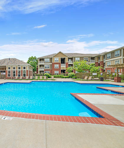 A large swimming pool in front of apartment buildings.
