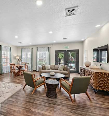 A well-lit, modern living room with a variety of seating options and a dining table.