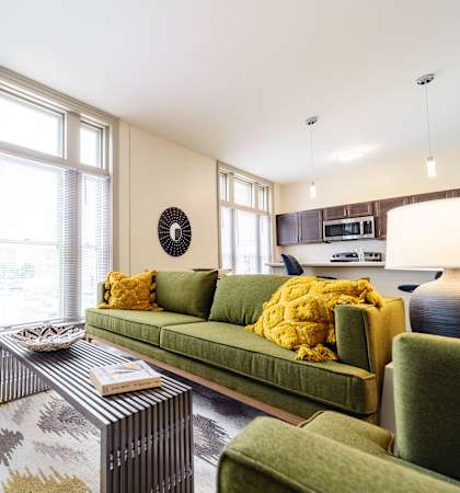 a living room with a green couch and a chair and a coffee table