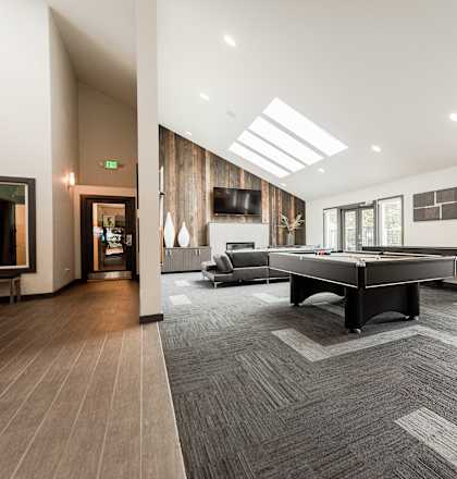 A spacious room with a long table and chairs at Ellyson Apartment Homes in Tacoma, WA