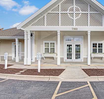 A white building with a porch and a sign that says 7960.
