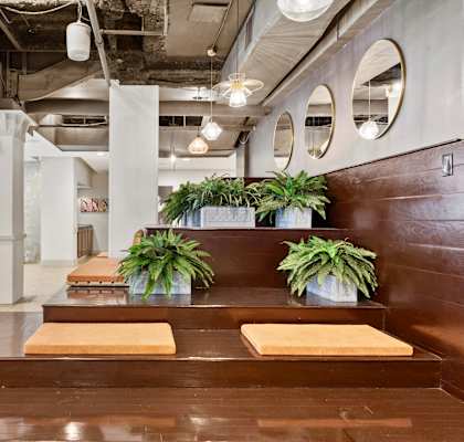 a large lobby with wooden benches and potted plants