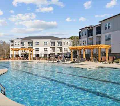 Swimming pool with lounge chairs and shaded cabanas at our Indian Land apartments.