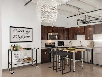 a kitchen with stainless steel appliances and a bar with stools