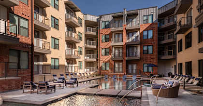 A pool area in front of apartment buildings.