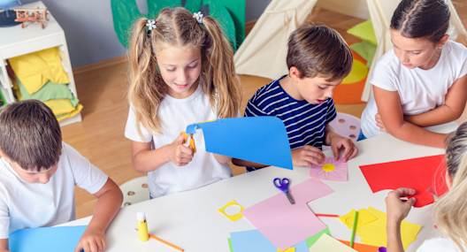 Children are engaged in a paper crafting activity.