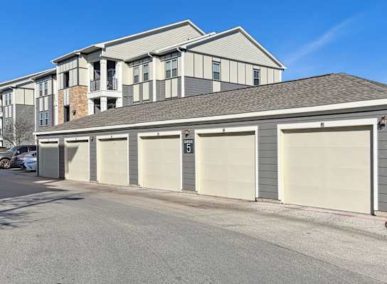 a garage with four doors in front of a house