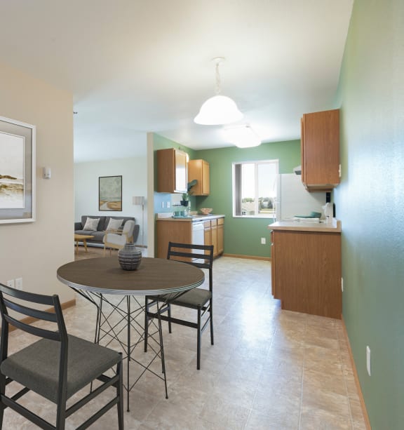 Bismarck, ND Sunset Ridge |a dining room and living room with a table and chairs and a kitchen Bismarck, ND Sunset Ridge |a dining room and living room with a table and chairs and a kitchen