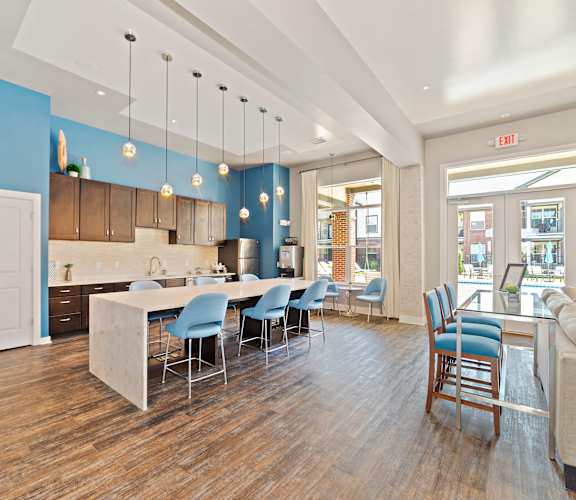 A kitchen with a dining table and chairs in the middle of the room.