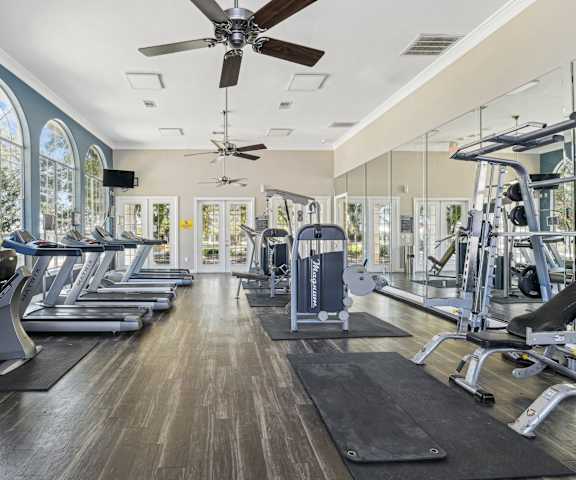a gym with cardio machines and a ceiling fan  at TalaVera Apartments, Texas, 78232