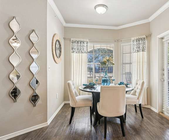 a dining room with a table and chairs and a window  at TalaVera Apartments, Texas, 78232