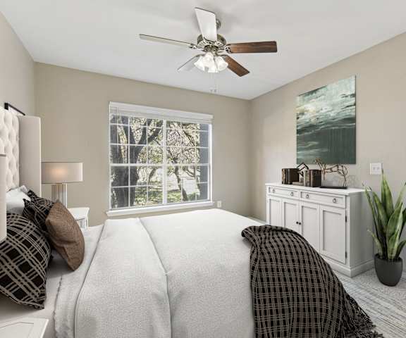 a bedroom with a large bed and a ceiling fan