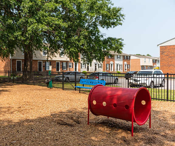 a red barrel sits in the middle of a playground