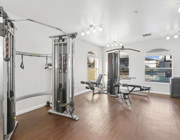 Fitness gym at Huntington Meadows Apartments with a squat rack, bench, weights, and various exercise equipment.