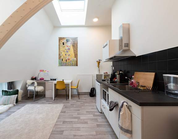 the kitchen and dining area of a house with a vaulted ceiling