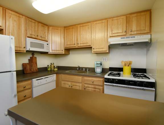 A kitchen with wooden cabinets and a white refrigerator.
