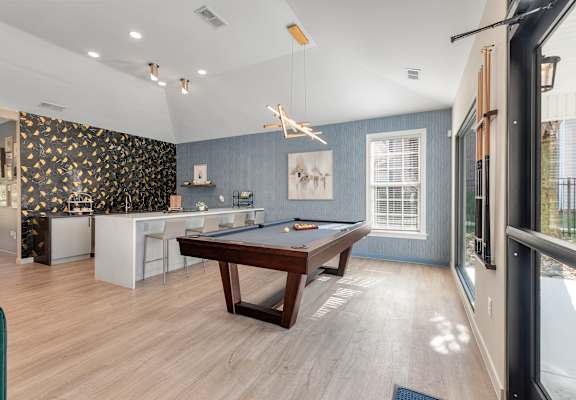 a game room with a pool table and a bar