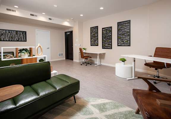 A living room with a green couch and a white coffee table.
