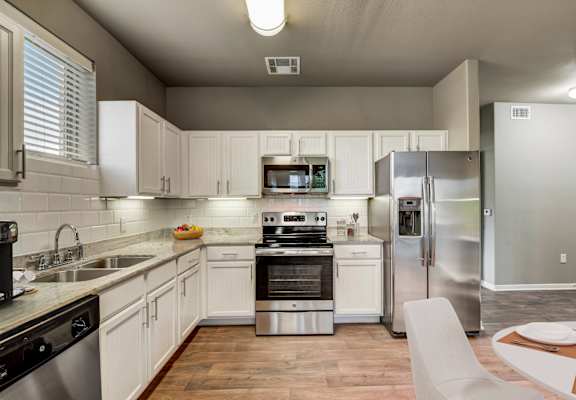 a kitchen with stainless steel appliances and white cabinets