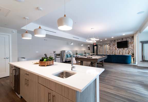 A modern kitchen with a white countertop and wooden cabinets.