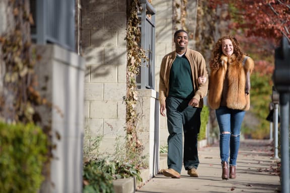 a man and a woman walking down a sidewalk