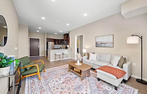 a kitchen and living room with a large island with a granite counter top at The Winslow 62+ Apartments, West St Paul, MN, 55118