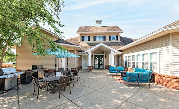 a large patio with a grill and tables and chairs