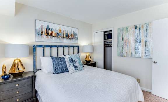 a bedroom with a large bed and paintings on the wall